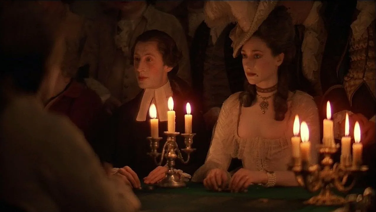 وجوه وملابس وأثاث حول ضوء الشموع في Barry Lyndon؛ مصدر الضوء جزء من إحساس المشهد بالزمن، وليس مجرد وسيلة لكشفه.