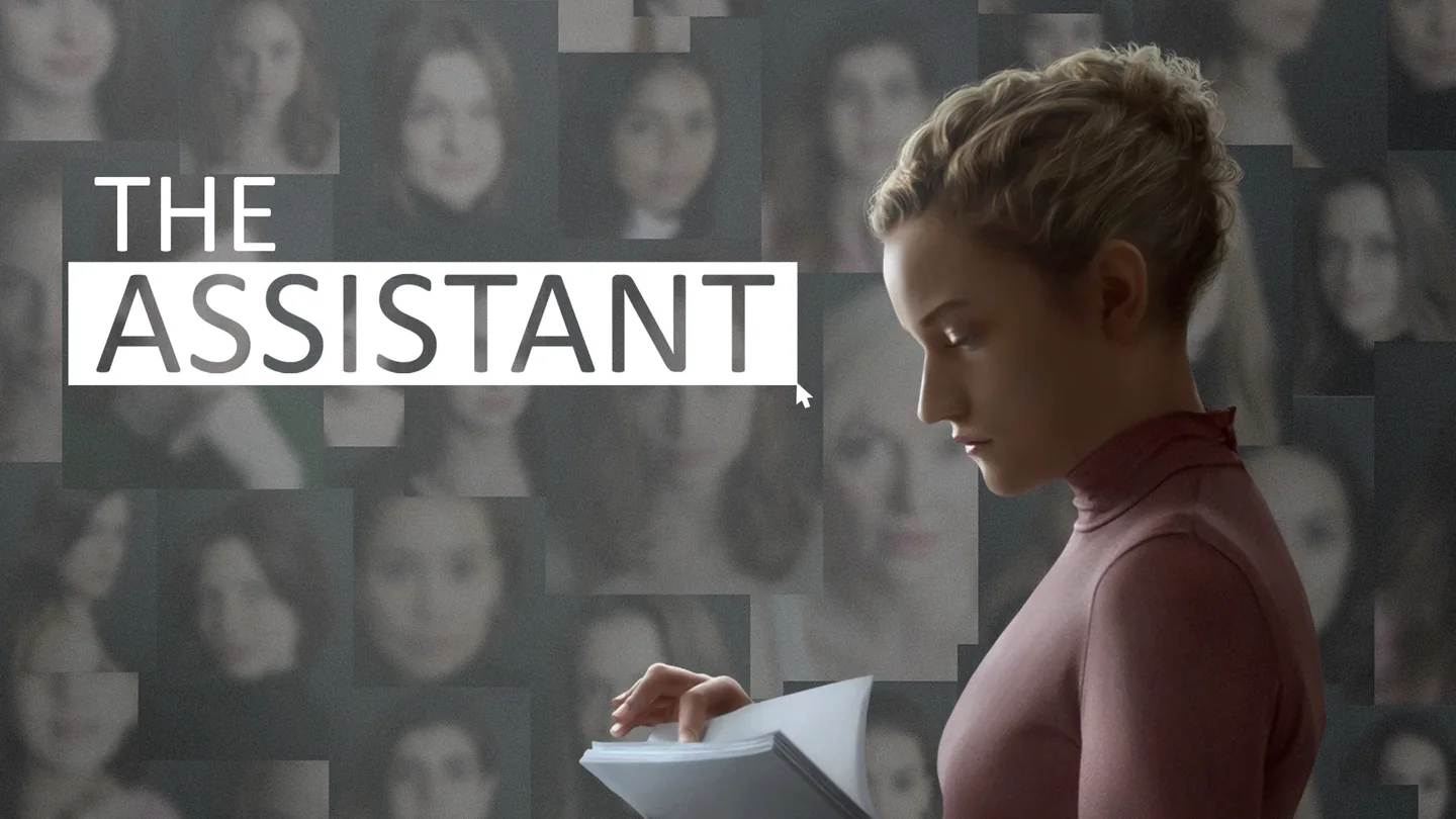 جين تمسك أوراقًا أمام خلفية من الصور الشخصية في صورة The Assistant.