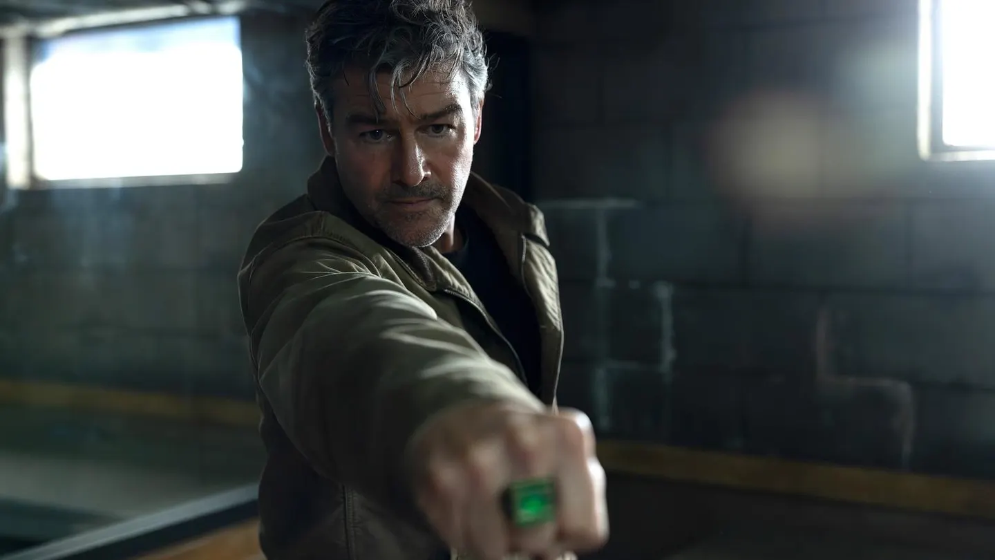 هال يمد قبضته بخاتم Green Lantern المضيء داخل مكان خافت الإضاءة