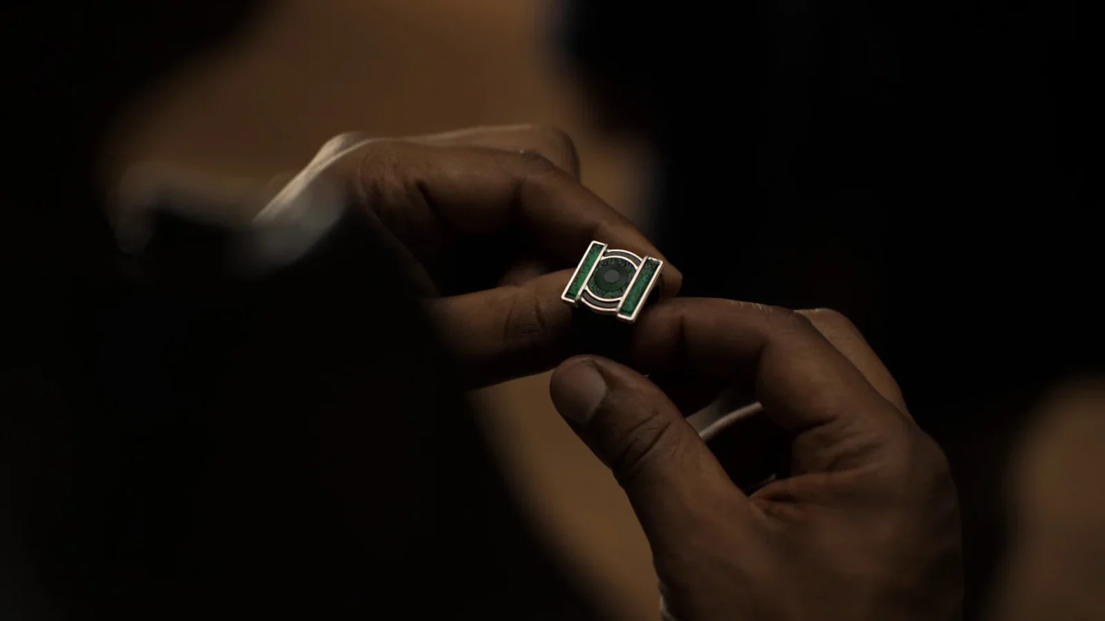 لقطة قريبة ليدين تمسكان بخاتم Green Lantern