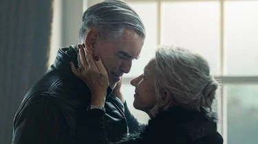مايف تلمس وجه كونراد بينما يقفان متقاربين قرب نافذة